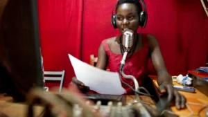 A radio presenter speaking into a microphone in a broadcast studio